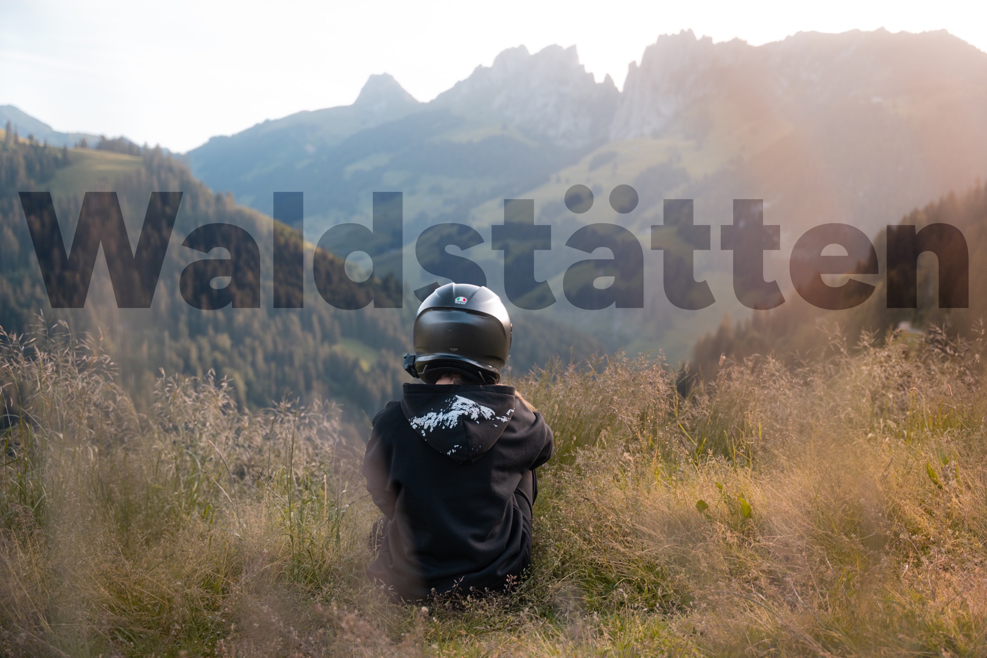 Pilote moto face aux Gastlosen à la golden hour, montagne imprimée sur le hoodie — campagne Waldstätten